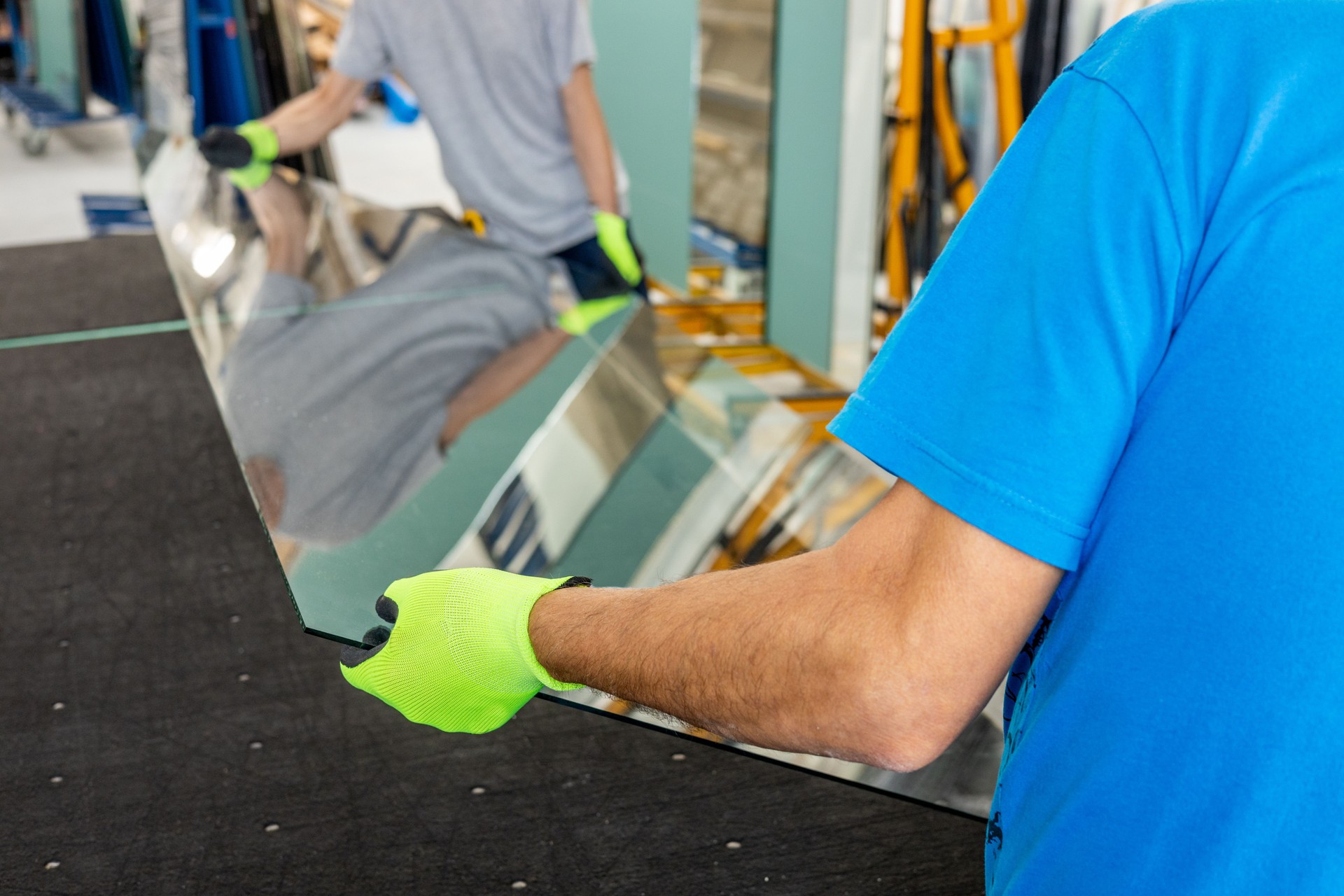 Skilled tradesperson installing thick custom-cut glass panel for electrical and glassworks project